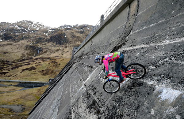 Adam Flint in bici sulla parete di una diga