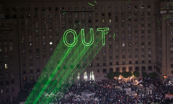 La scritta 'out' con un laser sui muri del Cairo
