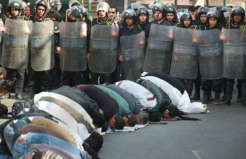 Fedeli in preghiera al Cairo circondati da poliziotti in tenuta antisommossa