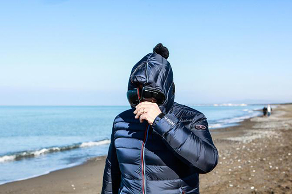 Beppe Grillo con cappuccio vestito da guitto in spiaggia