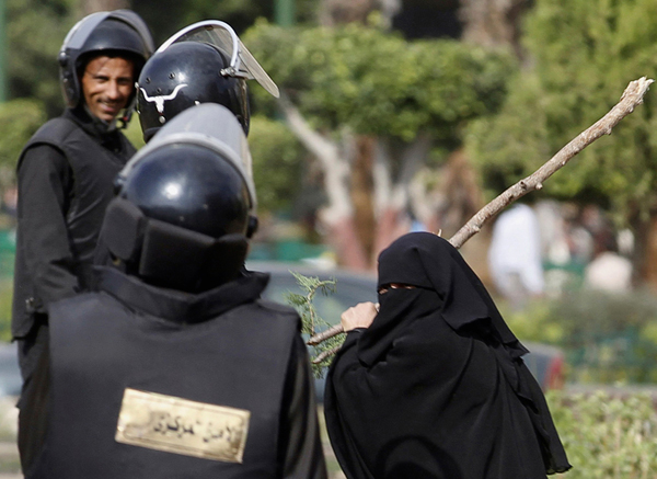 Una donna egiziana con un ramo tra poliziotti