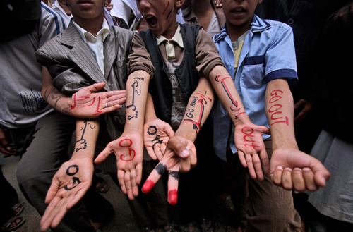 Dimostranti mostrano scritte contro il regime yemenita